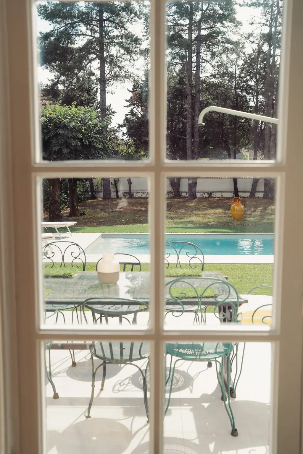 Le jardin et la piscine vus à travers la porte-fenêtre