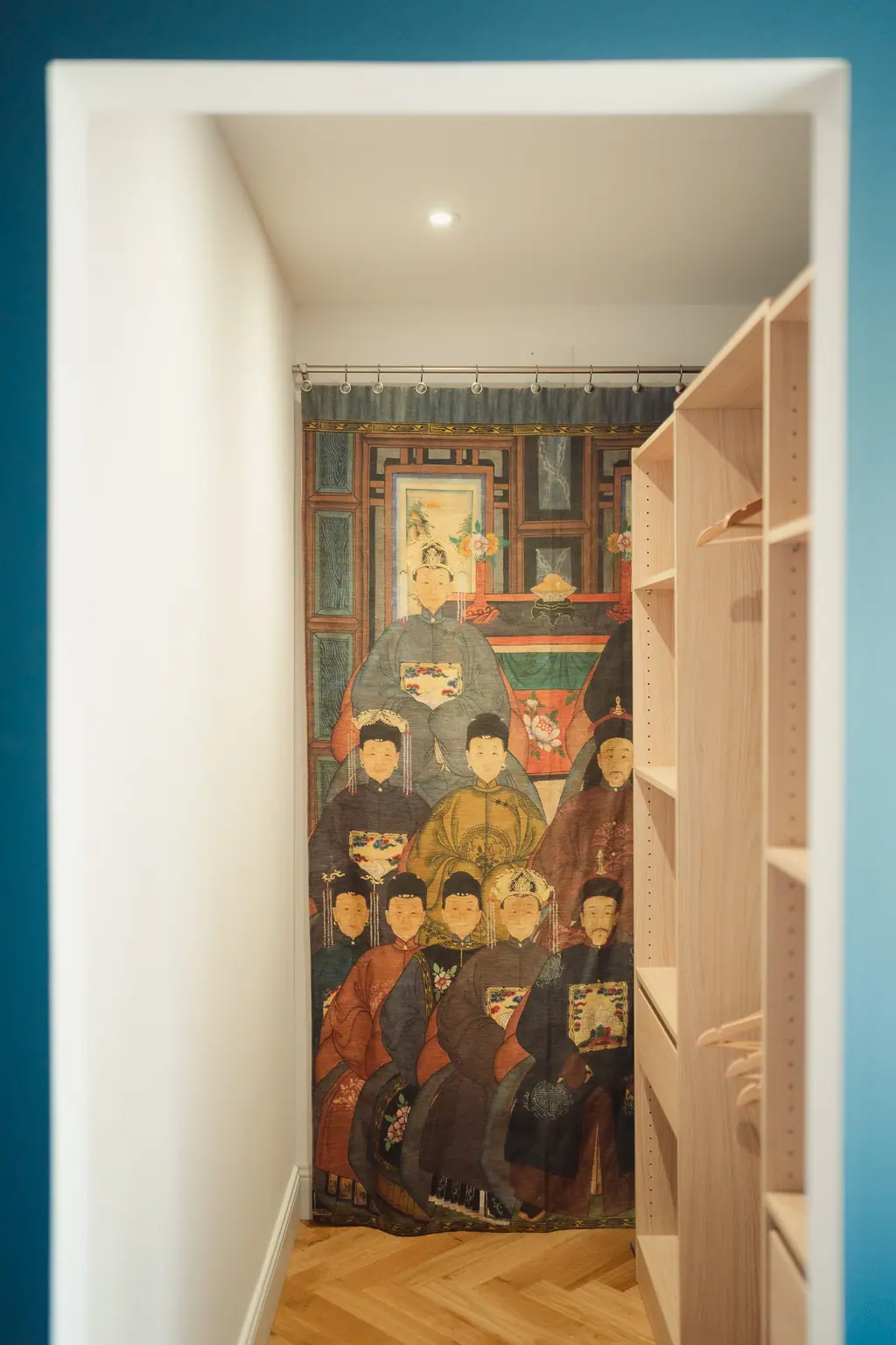 Le dressing en bois blond, un tableau ancien peint sur la paroi du fond