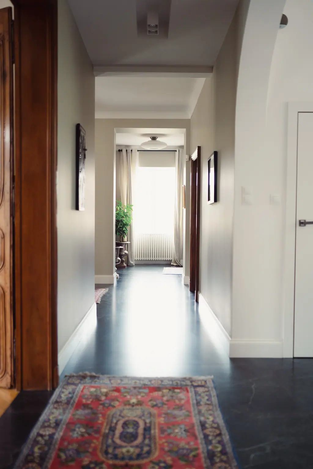 Le couloir et son tapis ancien, avec une fenêtre au fond