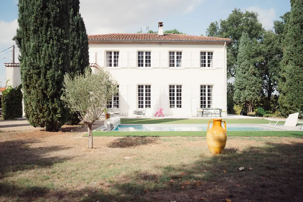 La maison entière, le jardin, un jeune olivier et la grande jarre ocre